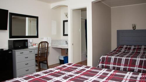 a hotel room with a bed and a sink at Motel de la mer in Rimouski