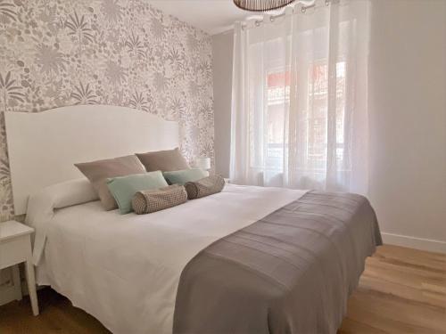 Housingleón San Juan Luxury Home في ليون: غرفة نوم مع سرير أبيض كبير مع نافذة