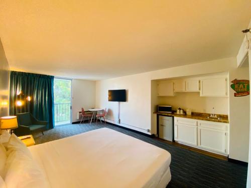 a hotel room with a large bed and a kitchen at Glendale Express Hotel Los Angeles in Glendale