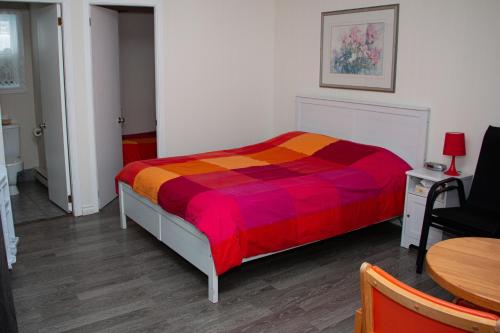 a bedroom with a bed with a colorful blanket at Motel de la mer in Rimouski