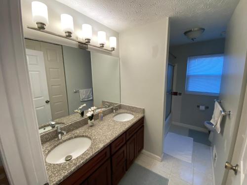 een badkamer met 2 wastafels en een grote spiegel bij Upgraded, beautiful 4 BD Colonial in Silver Spring in Silver Spring