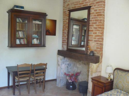 a living room with a table and a mirror over a fireplace at Chambres d'Hôtes & Gites Pouget in Les Eyzies-de-Tayac