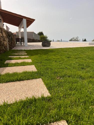 a grassy yard with a pathway leading to a building at NocasHouse Lousa in Fojo