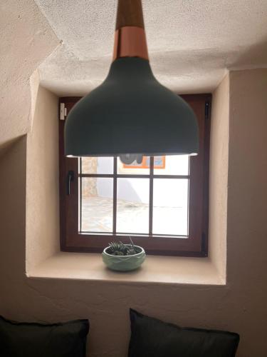 a lamp hanging over a window with a bowl in front of it at NocasHouse Lousa in Fojo