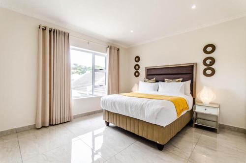 a bedroom with a large bed and a window at The Holy Hill Royal Alfred Marina in Port Alfred