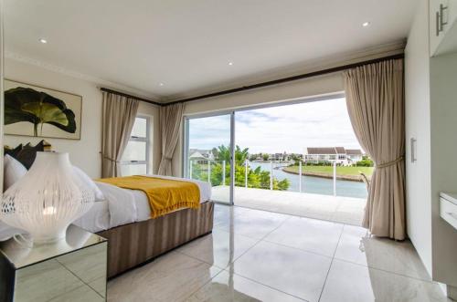 a bedroom with a bed and a large window at The Holy Hill Royal Alfred Marina in Port Alfred