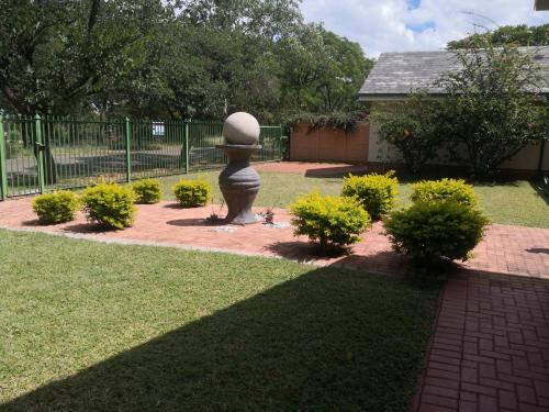 a garden with a statue in the middle of a yard at 15 On Reitz Bela bela in Bela-Bela