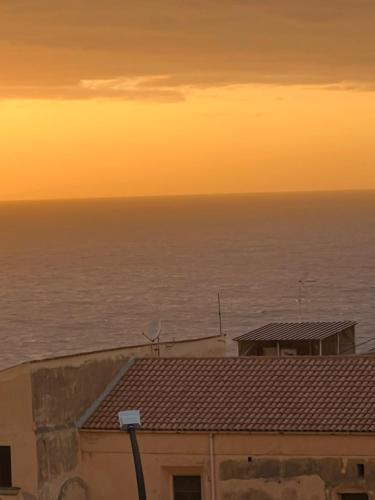 een uitzicht op de oceaan bij zonsondergang vanuit een gebouw bij Deus Accomodation in Tropea