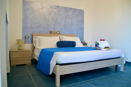 a bedroom with a blue and white bed and a nightstand at Sperlonga Paradise Suites 500m dal mare in estate Servizio navetta per Sperlonga centro in Sperlonga
