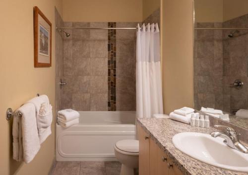 La salle de bains est pourvue d'une baignoire, de toilettes et d'un lavabo. dans l'établissement The Cove Lakeside Resort, à West Kelowna
