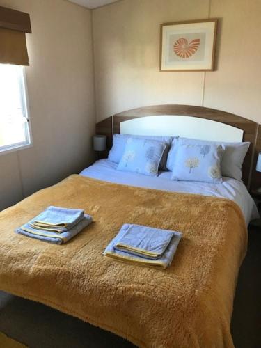 a bedroom with a bed with two towels on it at Spindrift in Rendham