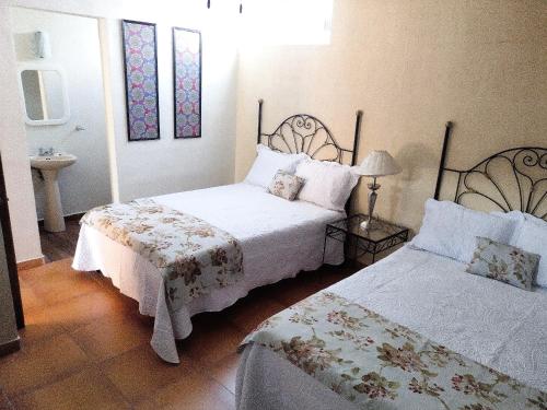 a bedroom with two beds and a sink in it at Casa Pueblo bonito in Bernal