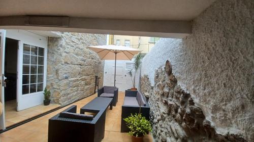 um pátio com bancos e um guarda-chuva num edifício em Casa O Castriño em Cambados
