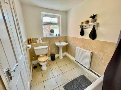 a bathroom with a toilet and a sink and a window at Spacious 3 bedroom retreat for professionals in Hull