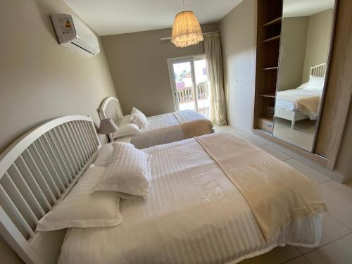 two beds in a hotel room with a mirror at Almaza bay Beach Town Chalet in Marsa Matruh