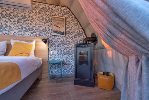 a bedroom with a bed and a curtain in a room at Au Champ de l'Insolite in Miers