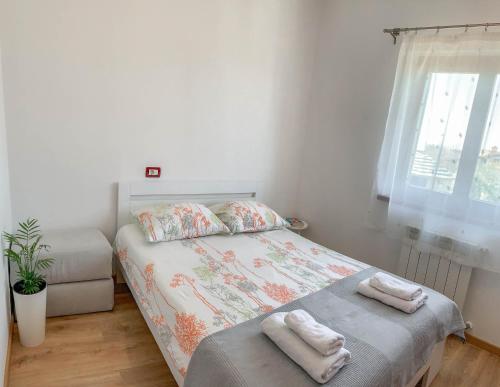 1 dormitorio con 1 cama con toallas en Apartments Leone, en Brtonigla