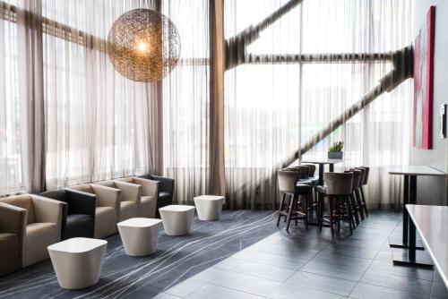 a restaurant with chairs and tables in a room with windows at Crowne Plaza Manchester City Centre by IHG in Manchester