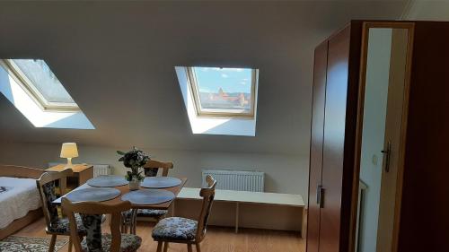 a room with a table and chairs and two skylights at Panorama in Trakai
