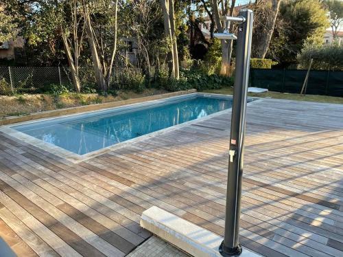 un pôle lumineux à côté d'une piscine dans l'établissement T2 GARDEN BEACH, à Saint-Cyr-sur-Mer