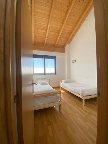 2 camas en una habitación con techos de madera en Vivienda de uso Turístico - La Garnacha en Rodezno