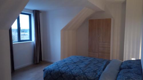 a bedroom with a blue bed and a window at Geevagh Holiday Home in Geevagh