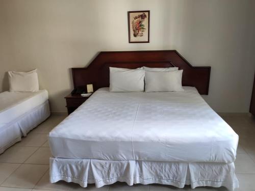 a bedroom with a large bed with white sheets at Suíte Hot Springs B3 Hotéis Hospedagem - Até 4 adultos in Caldas Novas