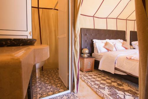 a bedroom with a bed and a tub and a mirror at Sunset luxury camp in Hassilabied