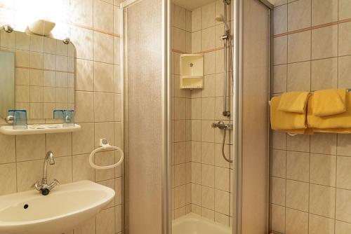 y baño con ducha y lavamanos. en Ostseehotel Neubukow en Neubukow