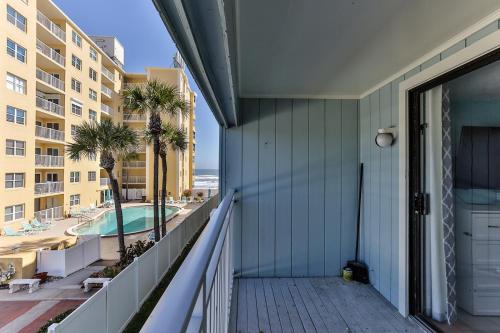 a balcony with a view of a pool and a building at Coastal Waters in New Smyrna Beach