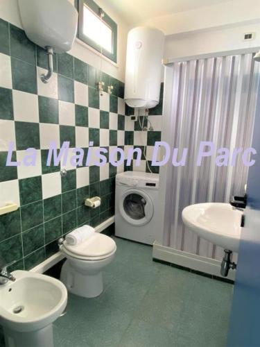 a bathroom with a toilet a sink and a washing machine at La Maison Du Parc in SantʼAndrea Apostolo dello Ionio