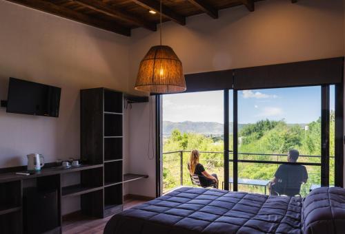 a bedroom with a bed and a balcony with a view at Campo Espinillo in Potrero de Garay