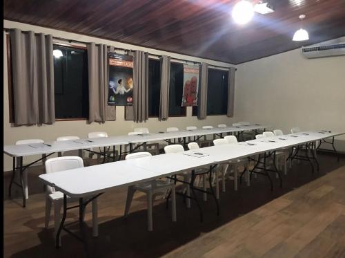 a large room with white tables and white chairs at Espaço Casa na Rocha in São José dos Campos