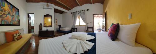 a bedroom with a large white bed with pillows at Hotel Diamante Sayulita in Sayulita