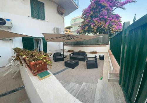 een patio met planten en een paraplu op een gebouw bij Riviera Albachiara Anzio B&B in Anzio