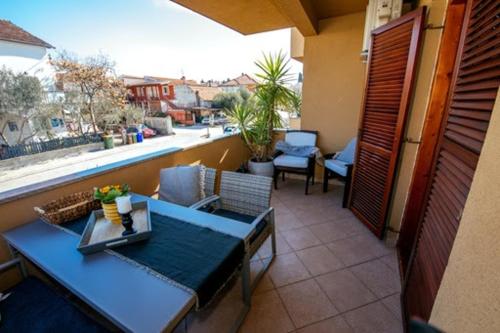 d'un balcon avec une table bleue, des chaises et une fenêtre. dans l'établissement M&M Apartments, à Biograd na Moru