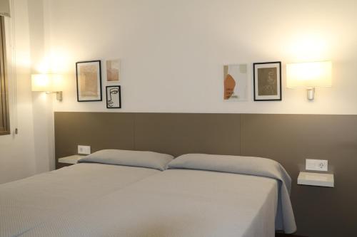 ein Schlafzimmer mit einem Bett und zwei Lampen an der Wand in der Unterkunft MyF Michelangelo Top in Salou