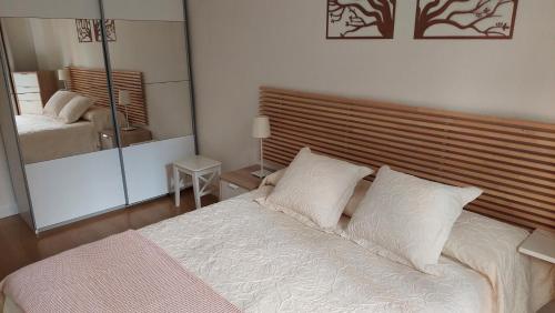 1 dormitorio con 1 cama grande con sábanas y almohadas blancas en Ibarrenea Apartamento, en Pamplona