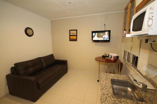 a living room with a couch and a tv at Tower Rock Puerto Deseado Standard in Puerto Deseado