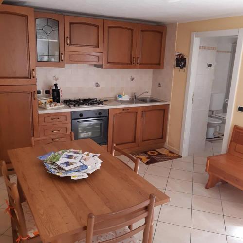 a kitchen with wooden cabinets and a wooden table at Le tue vacanze a Varzo, appartamento il girasole. in Varzo