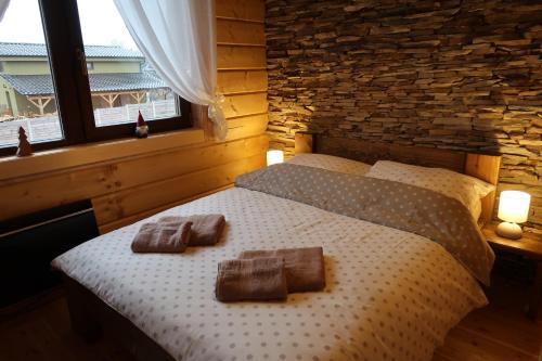 a bedroom with a bed with two towels on it at Chata Klaudi a Vilko in Veľký Slavkov