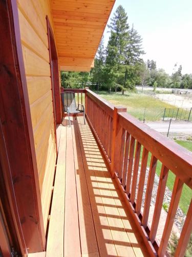 a balcony of a house with a wooden railing at Chata Klaudi a Vilko in Veľký Slavkov