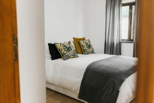 a bedroom with a white bed with pillows on it at Avenida in Elvas