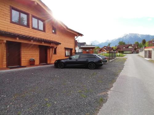 a black car parked in front of a house at Chata Klaudi a Vilko in Veľký Slavkov