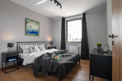 a bedroom with a bed and a window at M&J Apartments - Garden Gates in Gdańsk