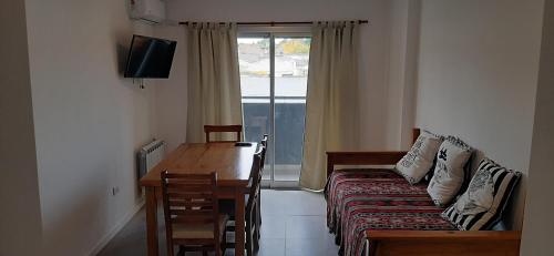 Habitación con sofá, mesa y ventana en Departamento Solares - San Martin en Bahía Blanca