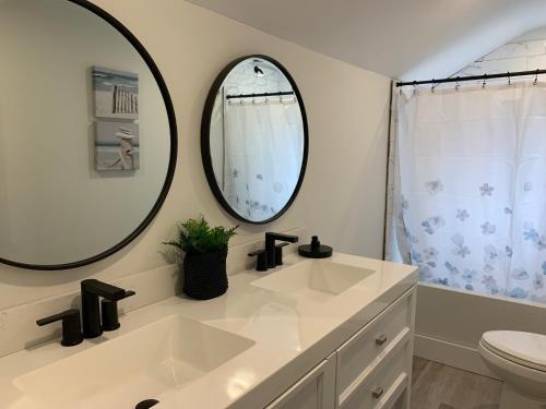 uma casa de banho com um lavatório, um WC e um espelho. em County Cove - Bloomfield Suite em Wellington