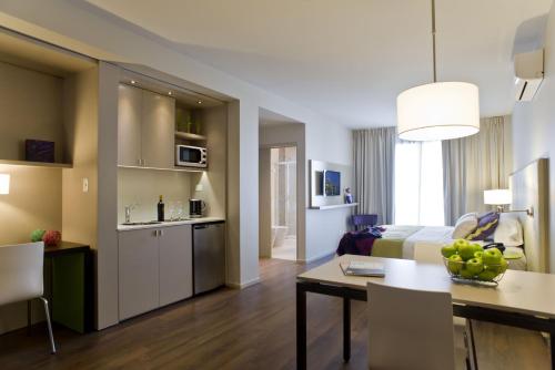 a hotel room with a bed and a dining room at Bulnes Eco Suites in Buenos Aires