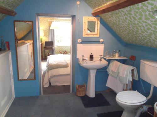 une salle de bains avec lavabo et toilettes et un lit dans l'établissement Cotswolds Mine Hill House, à Lower Brailes