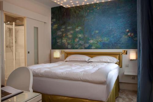 - une chambre avec un grand lit orné d'une peinture murale dans l'établissement Petit Madeleine Hôtel, à Paris